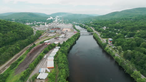 Aerial-View-of-Historic-Rumford-Mills-and-Foreground-River-under-Cloudy-Skies,-Maine