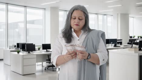 Indian-senior-businesswoman-counting-money