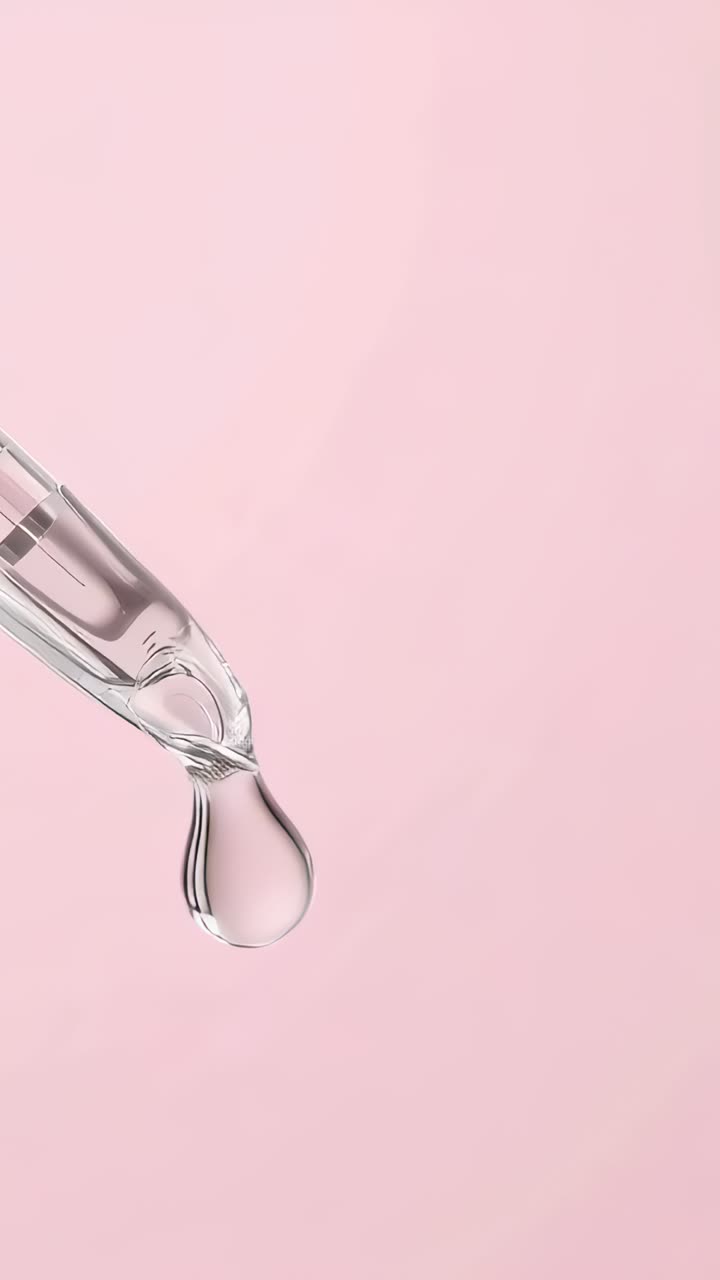 Video verticale: goccia che cresce, si stacca da un contagocce e cade su uno sfondo rosa, spazio per il testo