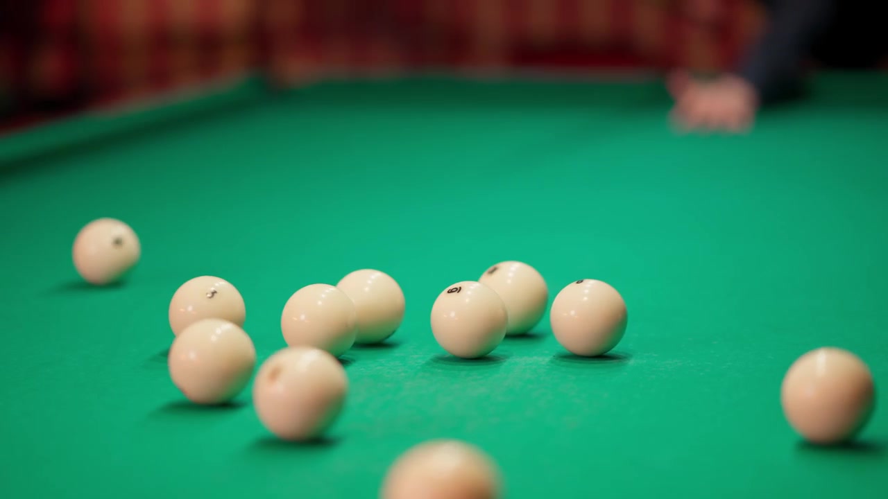 Cámara lenta de la bola de taco rompiendo el triángulo de bolas de billar blancas