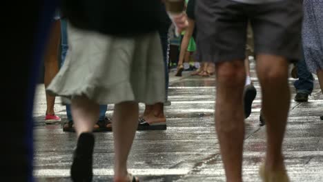 legs of crowd walking through rain in new york