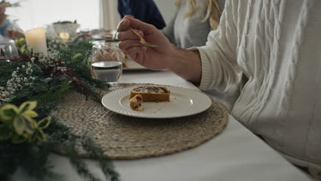 cerca del plato con el pastel de navidad y el hombre con la familia comiéndolos.