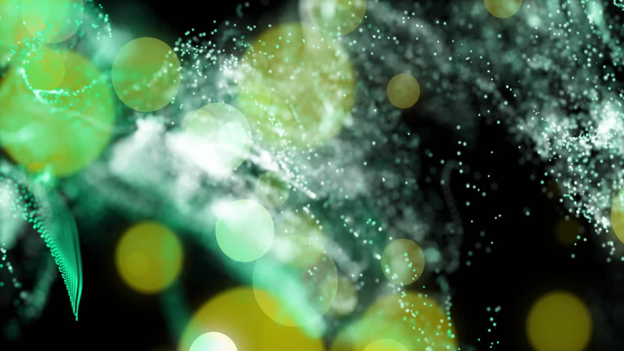 Abstract animation with green and yellow particles floating over dark background