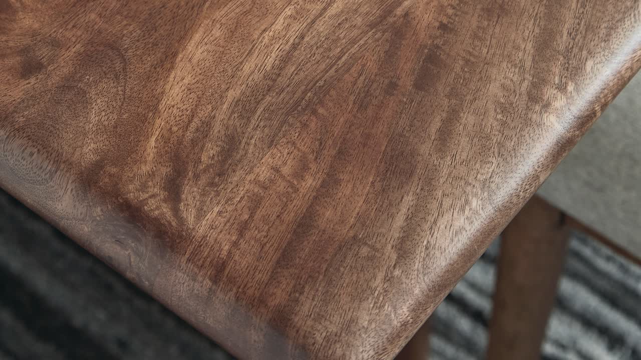 Camera rises along pristine slab, spotlighting grain and polished edge