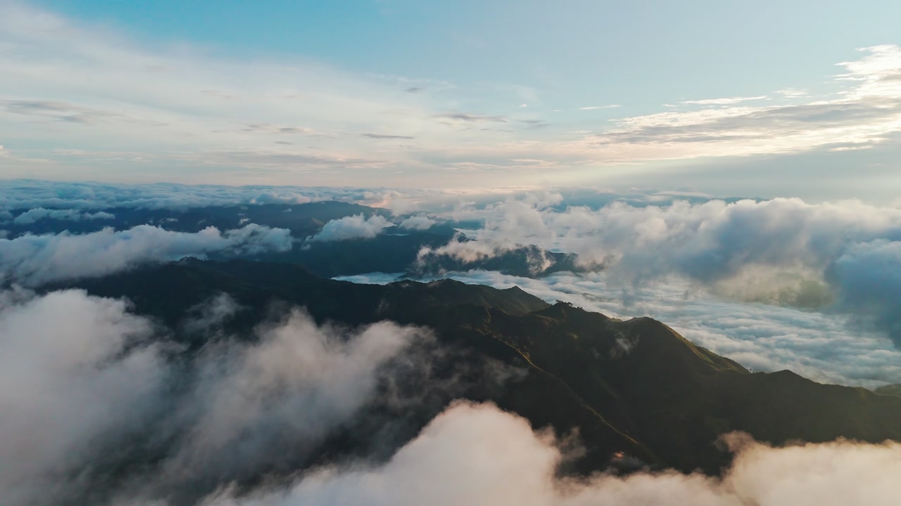 Majestic 4K drone shot above misty mountain ridges at sunrise, with dramatic clouds and sweeping cinematic atmosphere.