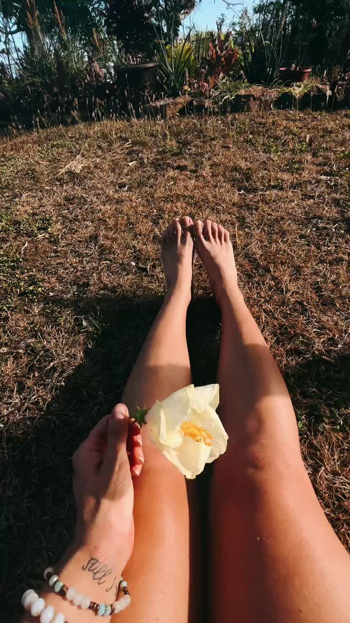Donna che si rilassa in giardino con un fiore