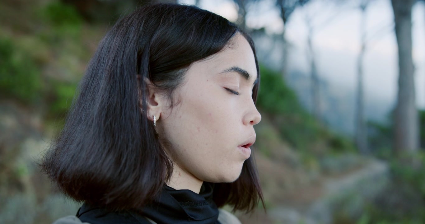 屋外の自然の中で深呼吸をする若い女性