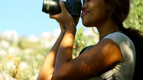 excursionista mujer haciendo clic en fotos con cámara digital 4k
