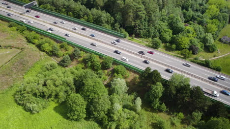 Carretera-Rodeada-De-Exuberante-Vegetación-Con-Vehículos-Que-Viajan-En-Gdynia,-Polonia---Toma-Aérea-De-Drones