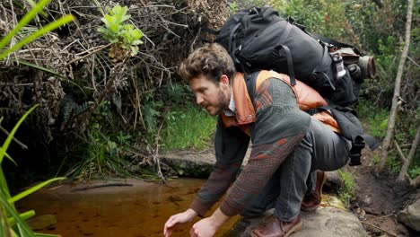 male hiker washing his face with water 4k