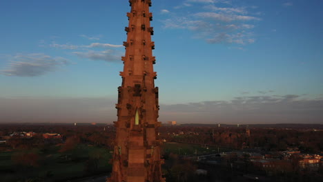 una toma aérea del campanario de una catedral con una cruz en la parte superior, tomada al amanecer