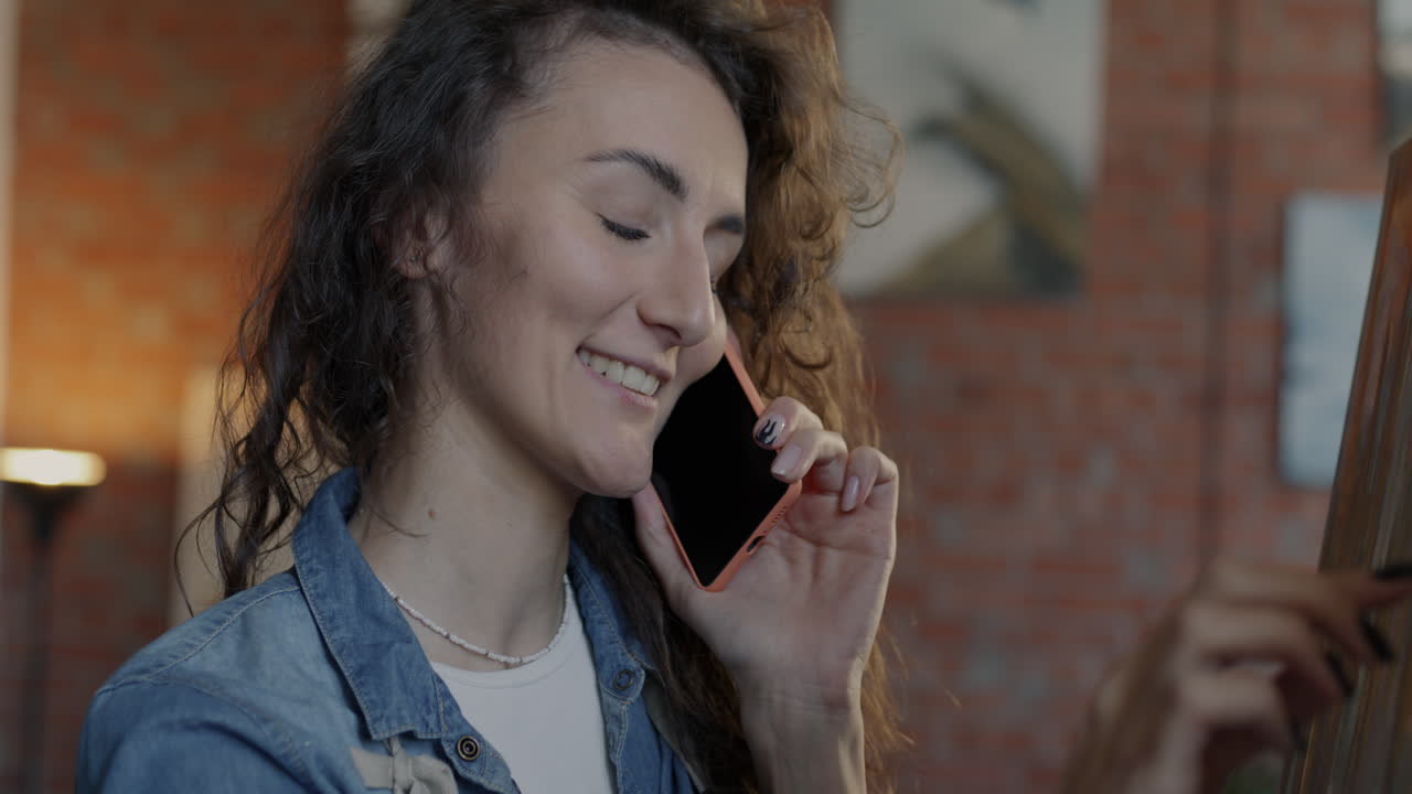 Woman Artist Talking on Phone in Studio