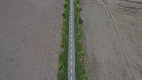 Volando-Sobre-Un-Pequeño-Carril-Bici-En-Medio-De-Un-Campo-Arado