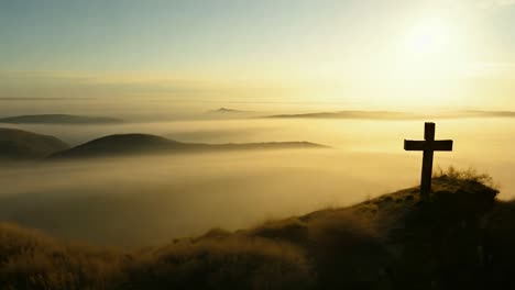 cruz en la cima de una montaña al amanecer o al atardecer