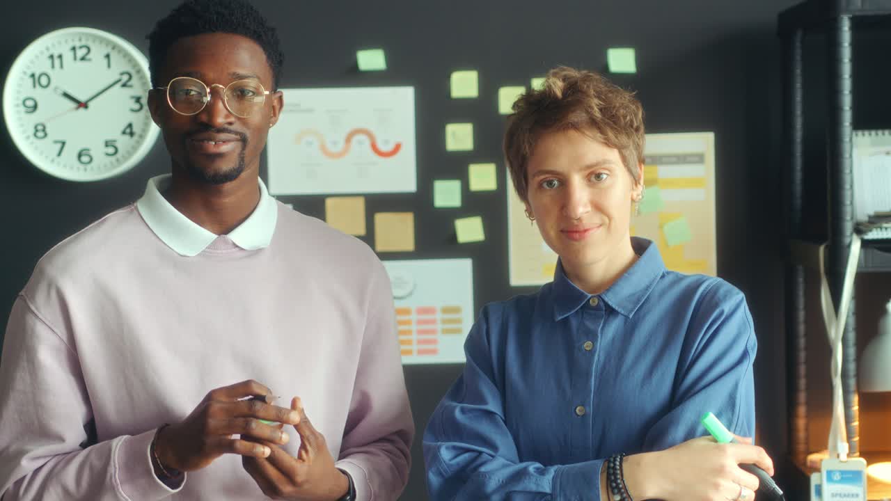 Portrait of Two Diverse Colleagues Smiling at Camera in Office