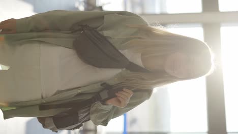 portrait of a stylish young blonde girl traveller stands in airport terminal