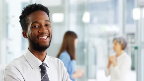 Businessman-standing-with-arms-crossed-in-office