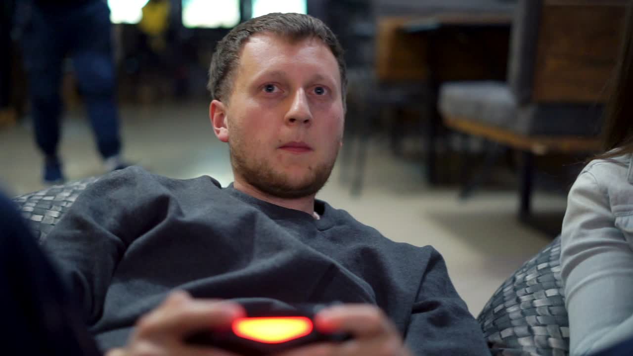 pareja joven jugando videojuegos en casa. disparar y controlar usando el controlador de juego. controlador de juego inalámbrico. cámara lenta