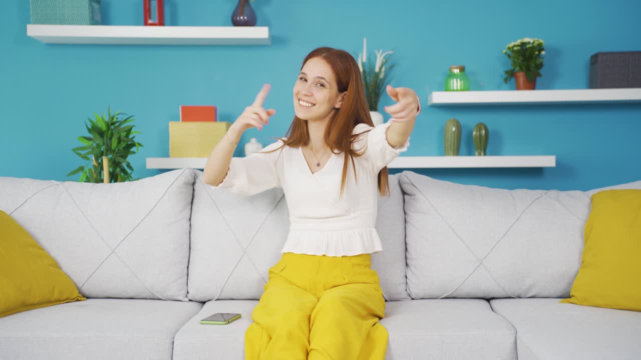 카메라에 맞춰 춤을 추는 행복한 젊은 여성.