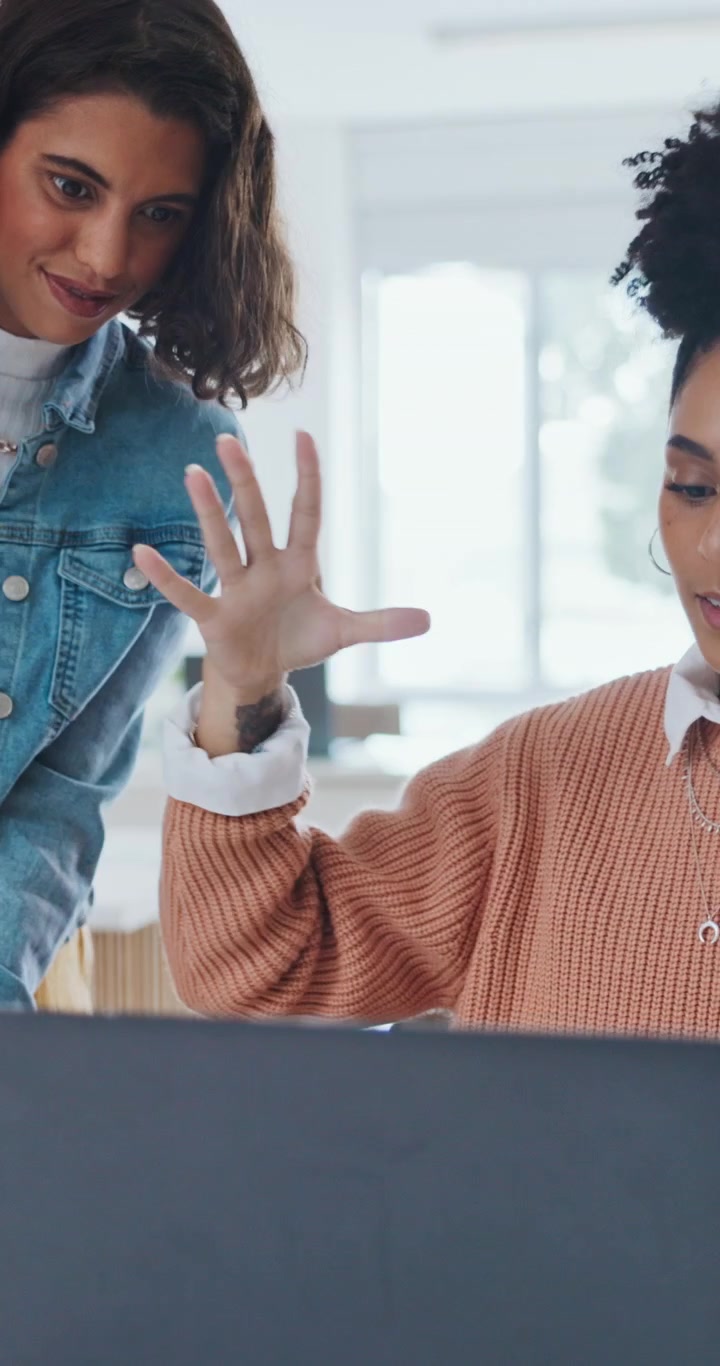 Two Female Colleagues Celebrating Success with a High Five in Office