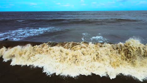 vasi beach rajodi daone s hot of beach camera tilt up on rockes moving cloudes india maharahstra surfing under blue sky brown sea fall in waves