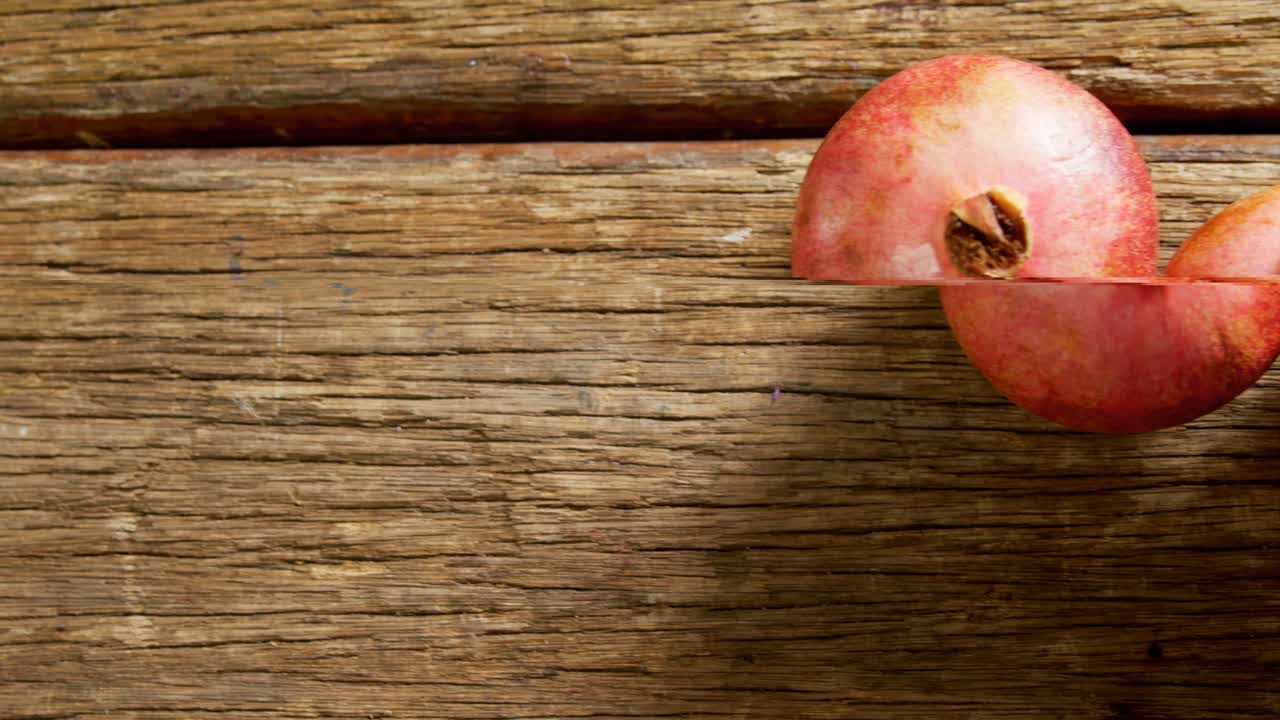 Two pomegranates on a wooden table 4k