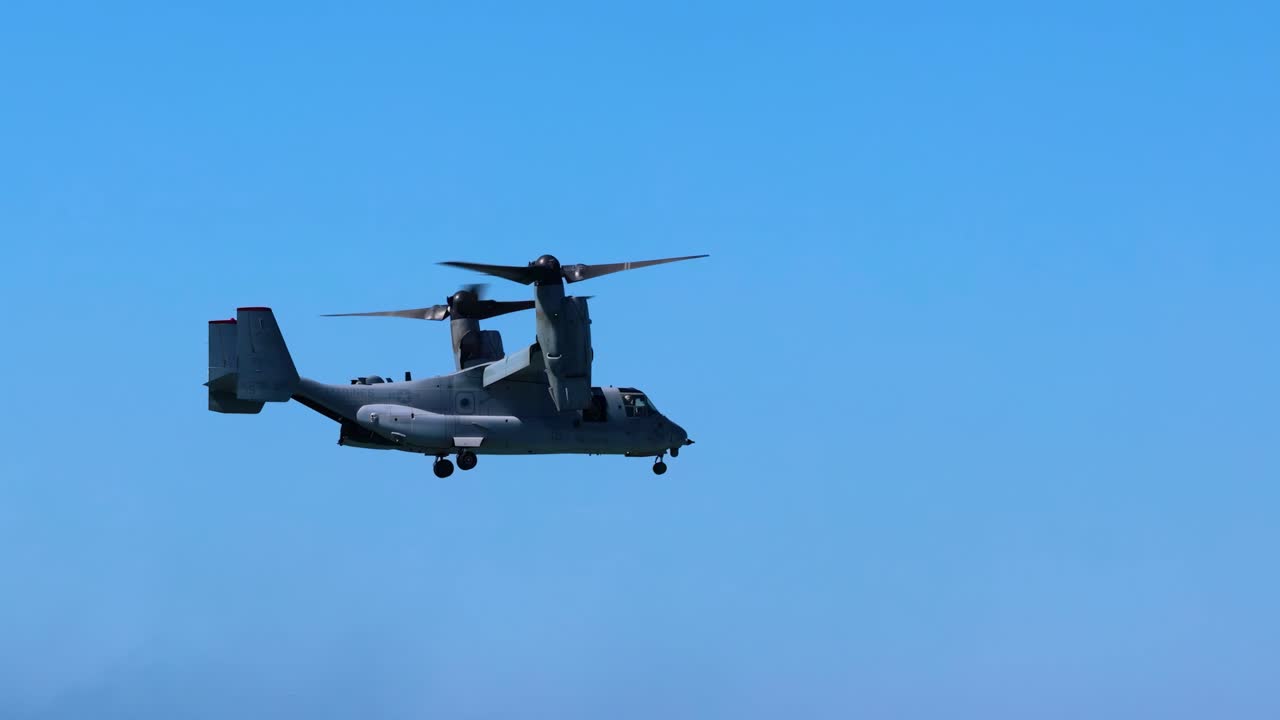 A helicopter hovers steadily against a bright blue sky, showcasing its flight capabilities.