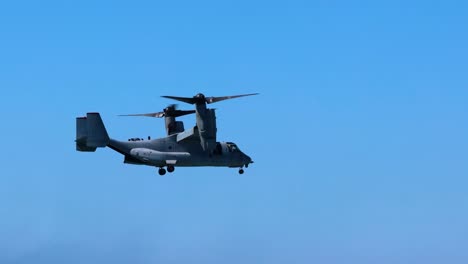 a helicopter hovers steadily against a bright blue sky, showcasing its flight capabilities.