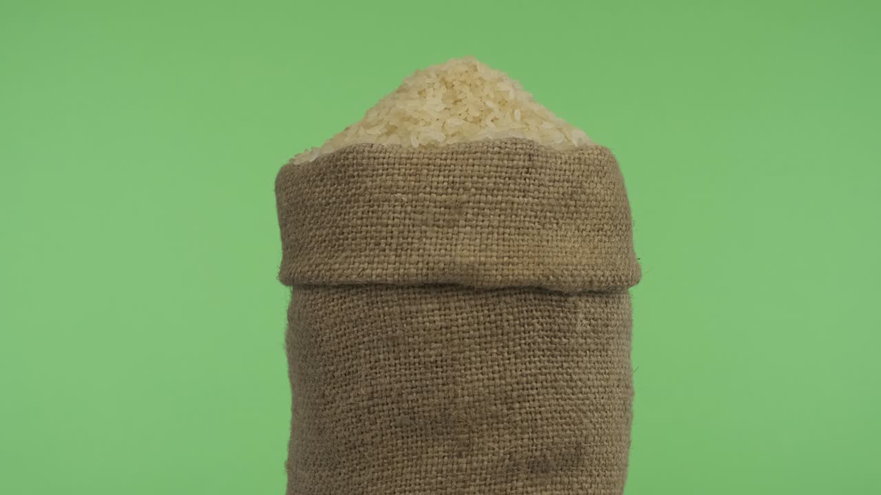 Rotating a full bag of rice grain. Close-up.