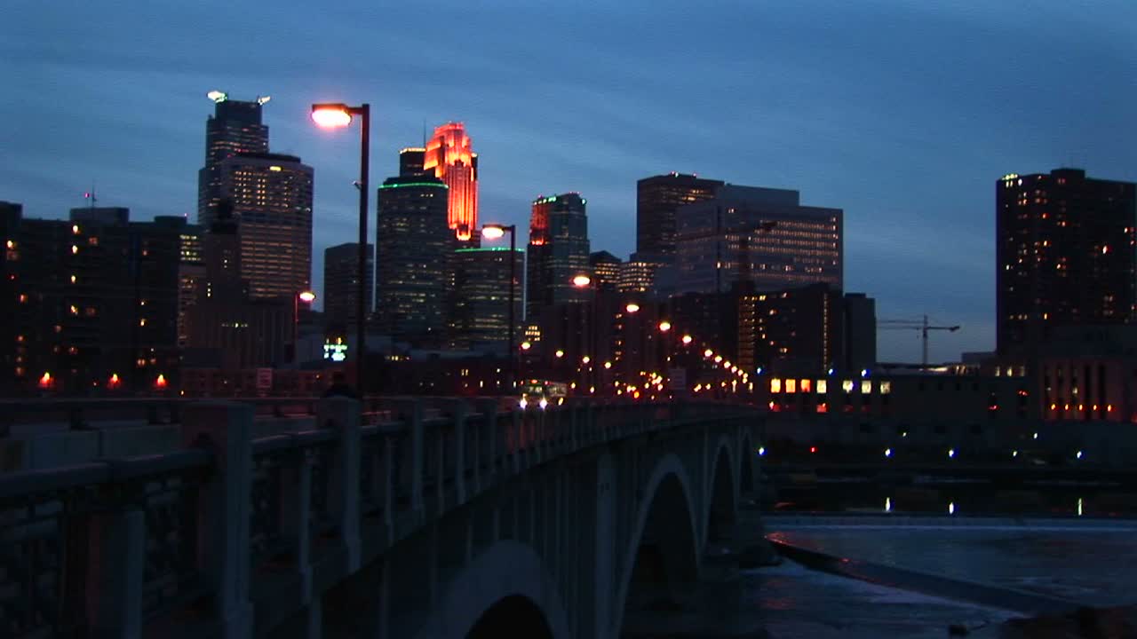 미네소타 미니애폴리스 해안가를 따라 미시시피 강 다리에서 야간 교통의 중간 폭 샷