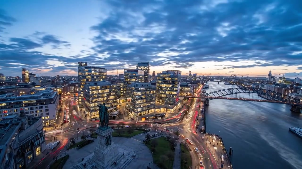 Een Prachtig Panoramisch Uitzicht op een Stadsskyline in de Schemering, met Hoge Gebouwen, Verlichte Straten en een Kalme Rivier die de Schemerkleuren Weerspiegelt.