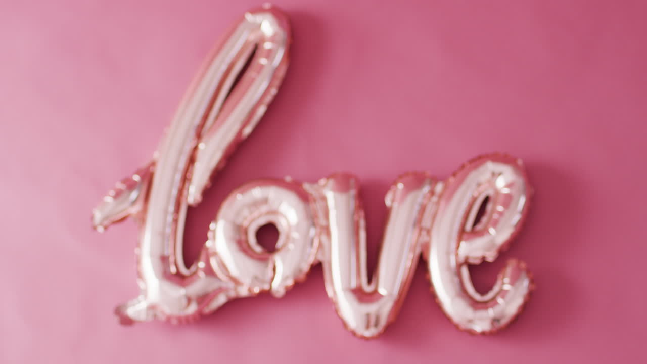 video de enfoque de rack de un globo de texto de amor de color rosa pálido brillante, sobre fondo rosa con espacio para copiar