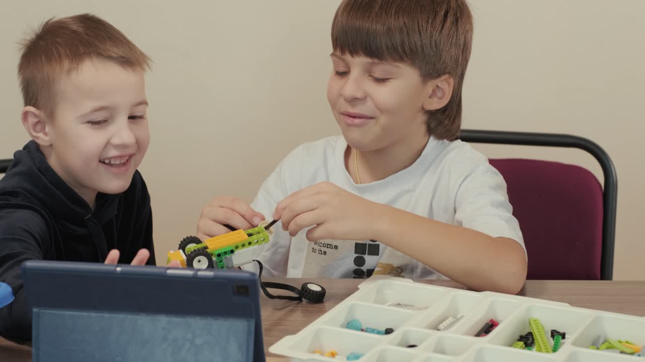 los niños participan en actividades de aprendizaje básico, montando kits de robótica con enfoque y trabajo en equipo en un entorno de aula
