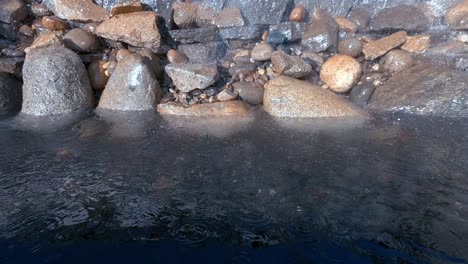 gotas de lluvia caen sobre una piedra preciosa con una cascada