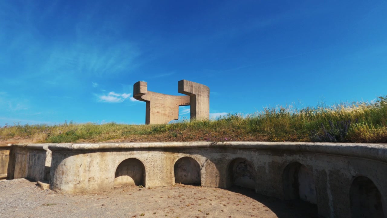 Statische Aufnahme auf Bodenniveau der Betonskulptur Elogio del Horizonte vor blauem Himmel in Gijón, Asturien.