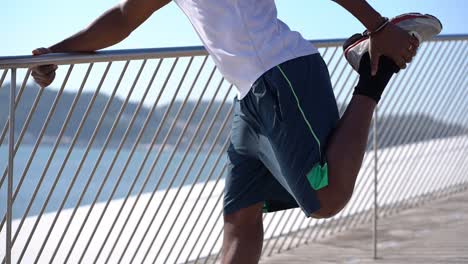 Cropped-shot-of-man-stretching-leg-on-bridge