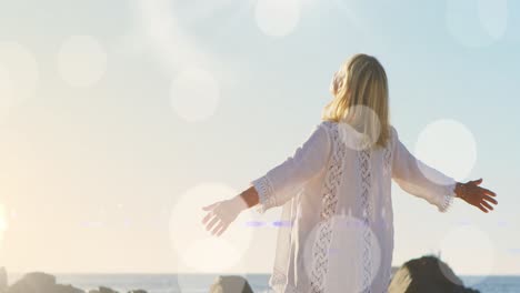 animation of light spots over disabled caucasian woman with arms outstretched