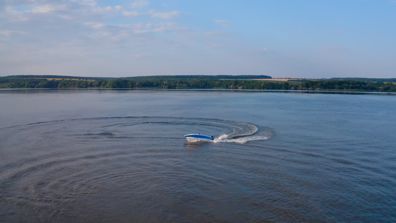Motorboat on blue water surface. Tourists travel in a high-speed boat in the sea. White foam after the boat sailing on water. Aerial view