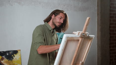 happy man painting on a canvas