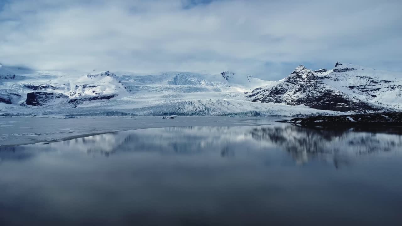 montañas rocosas nevadas a orillas del lago en el día de invierno