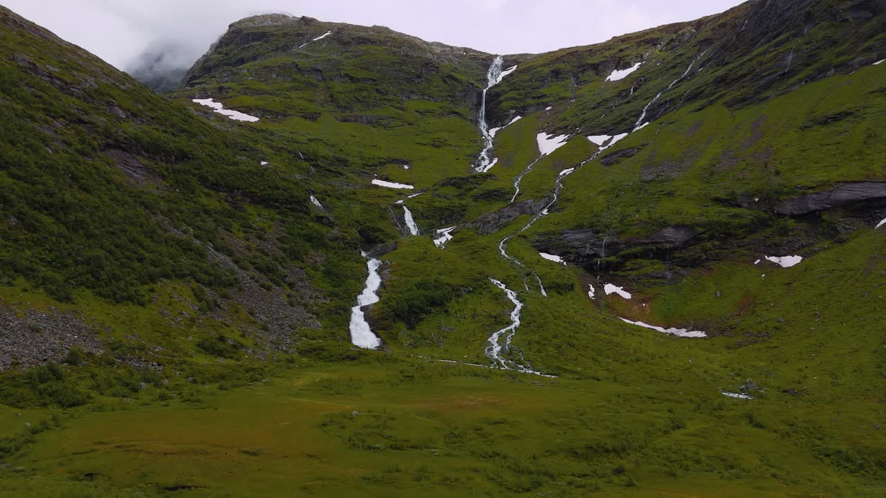 Beautiful traditional houses huts next to natural waterfall at Geiranger Fjord. Norway Scandinavia nature