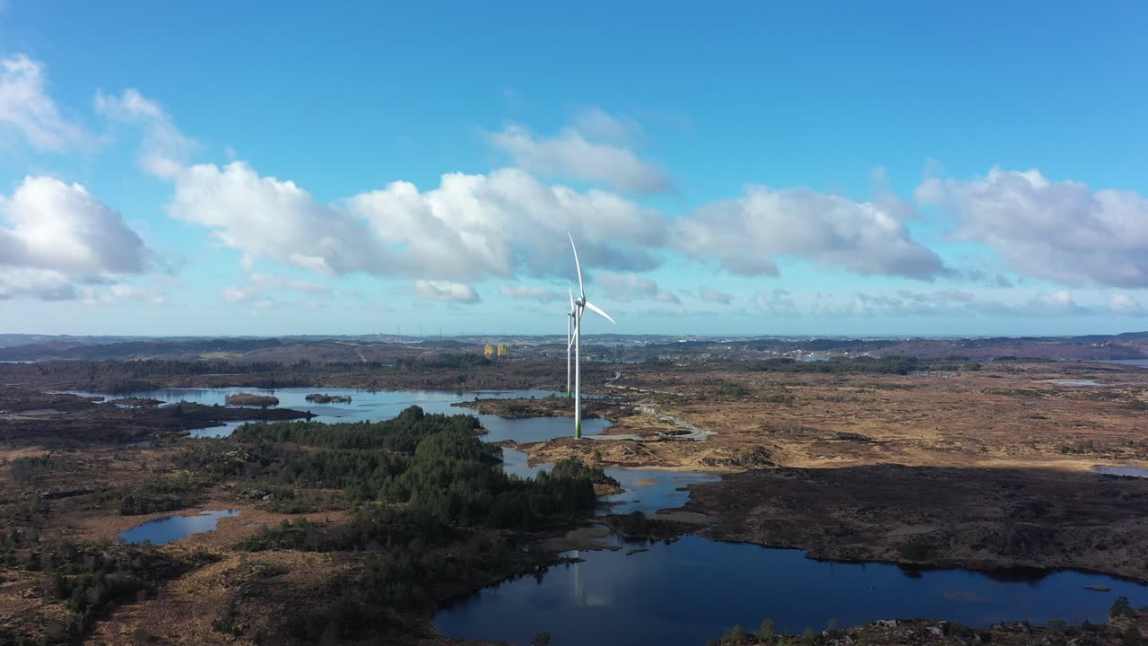 duas turbinas eólicas enercon em gismarvik, noruega, durante um belo dia de sol - vista panorâmica aérea mostrando uma turbina rotativa e outra parada na área úmida natural