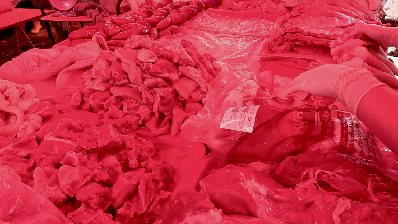 Tukang daging menata potongan daging di pajangan