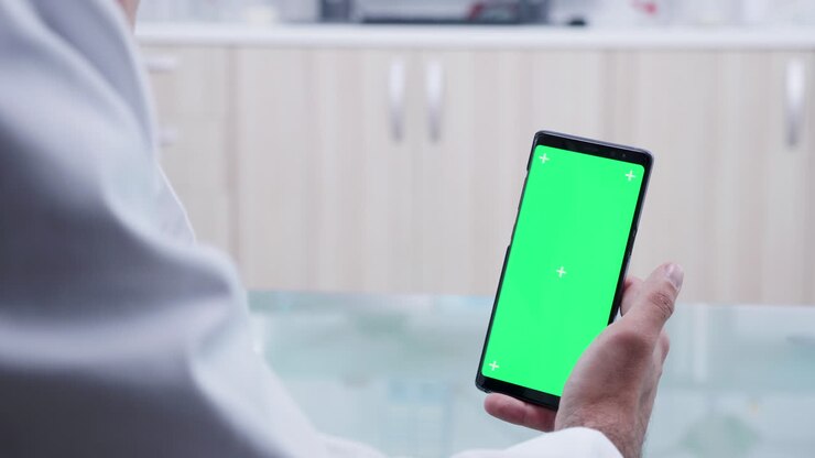 Smartphone with green screen held by a man