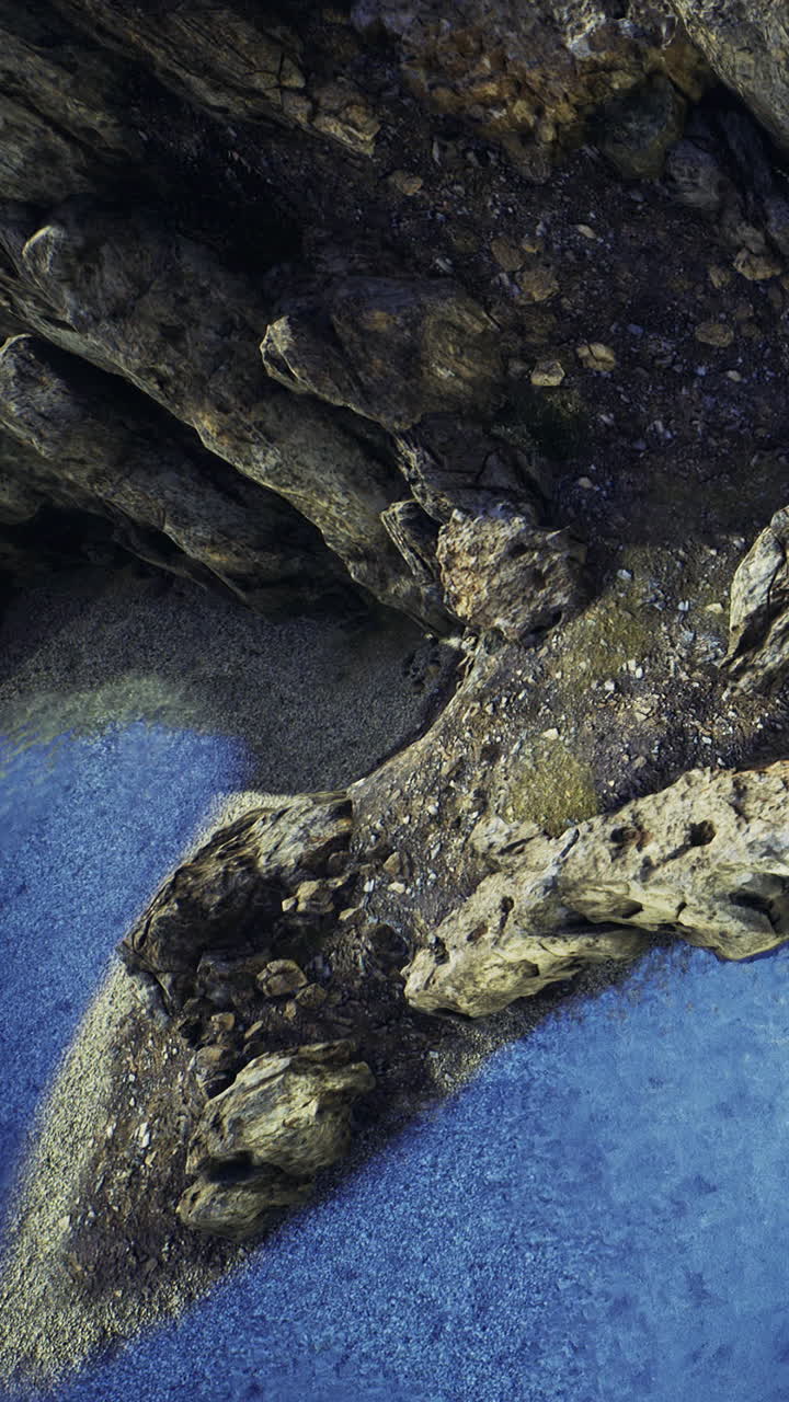 Costa rocciosa incontra acqua blu in un'area costiera isolata durante il giorno