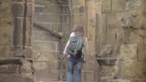 woman walking through ruins of old church in england