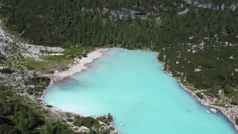 lake sorapis in between green mountain forest, deep turquoise water colour