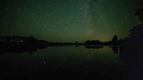 dramático lapso de tiempo del cielo nocturno estrellado de la vía láctea que cambia de color y se refleja en el agua