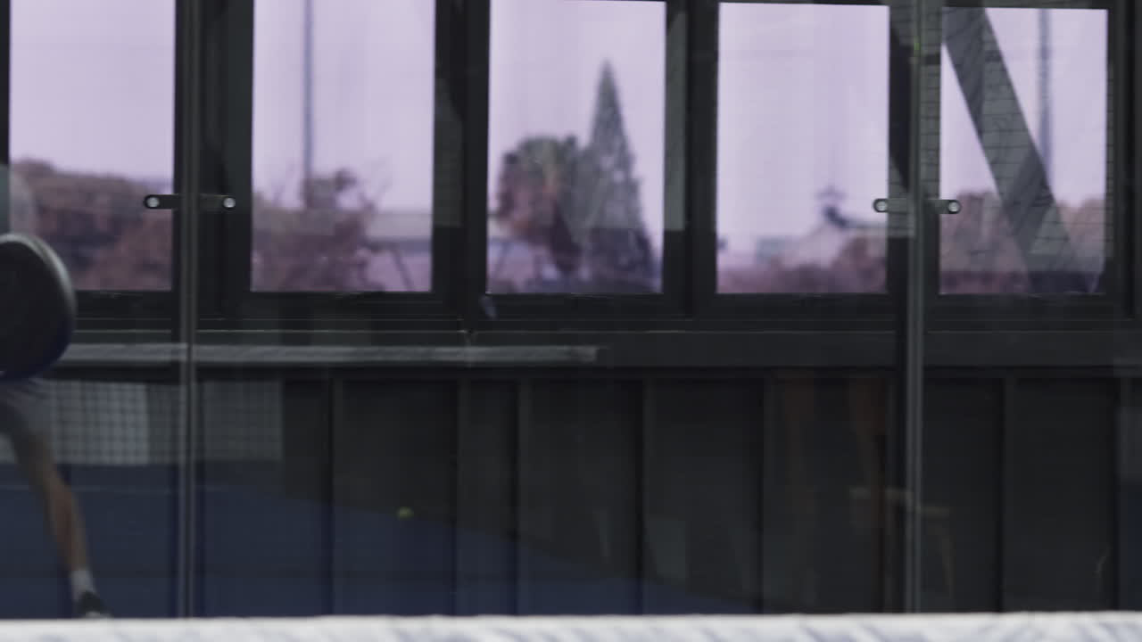 Entering padel court man bouncing ball and woman dribbling ball on rackets warming up