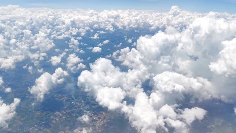 stunning footage of aerial view above clouds from airplane window with blue sky. view from the airplane window to the blue sky and white clouds. view of the earth from the sky through the clouds